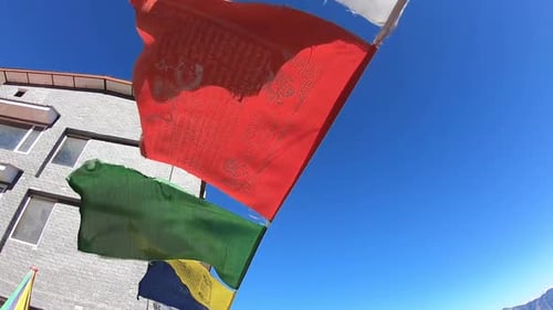 Buddhist flags blowing with wind on a hill top during broad daylight. old asian mountain village in