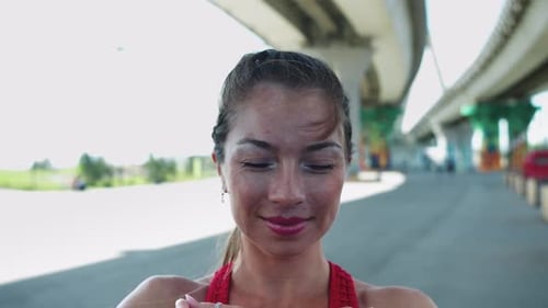 Eine lächelnde erwachsene Frau posiert mit ihrer Hand unter der Brücke