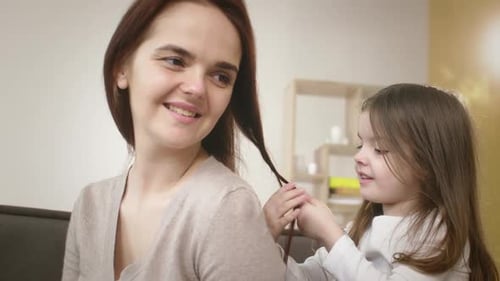 Mother and Daughter Sharing a Tender Moment Braiding Hair at Home