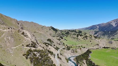 Aerial Panorama Showcasing a Serene Mountain Valley with a Winding River Lush Green Hills