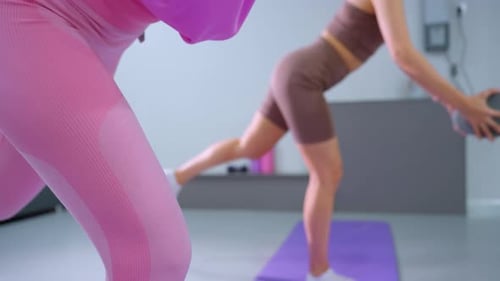 Women Exercising and Balancing Indoors on Exercise Mats