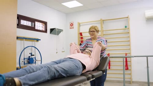 Woman Assisted Stretching by Healthcare Professional in Clinic