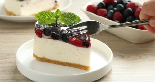 Delicious Berry Cheesecake Slice Being Cut with Fork