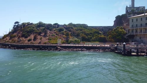 Gimbal close-up panning shot of the landing dock and welcome center at Alcatraz Island from a movin