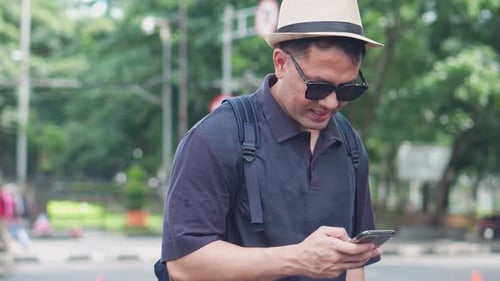 Man Using Smartphone on City Street