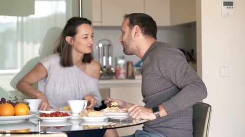 Couple enjoying breakfast and kissing at home