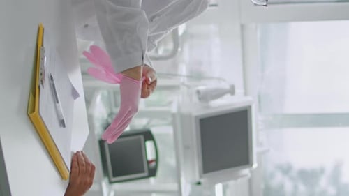 Medical Professional Putting On Gloves in Hospital Room