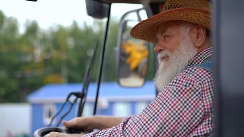 Senior Man Smiling in Tractor on the Farm