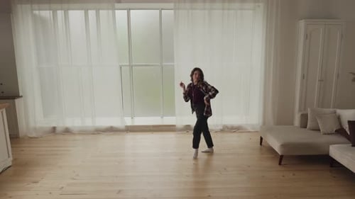 Young Woman Dancing Happily in Light-Filled Home