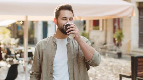 Young Man Guy Enjoying Drinking Morning Coffee Hot Drink Relaxing Taking a Break in City Street
