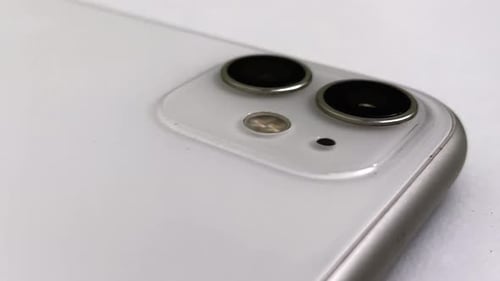 Mobile Phone with Pair of Cameras Lies on White Surface