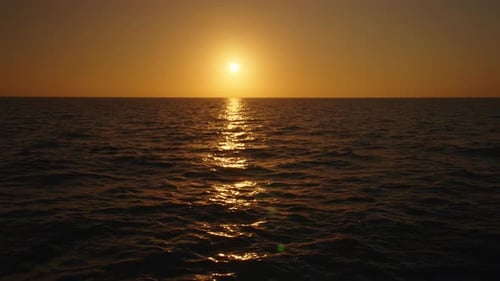 A Captivating Sunset Over Glistening Ocean Waves in Slow Motion