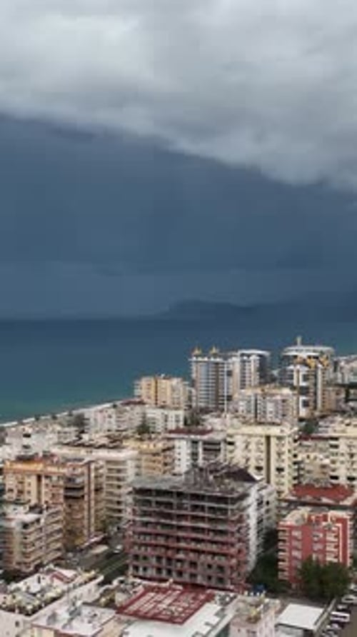 Vertical Video Aerial Escape Stormy Mediterranean Coastline and City Panorama Amidst the Warning