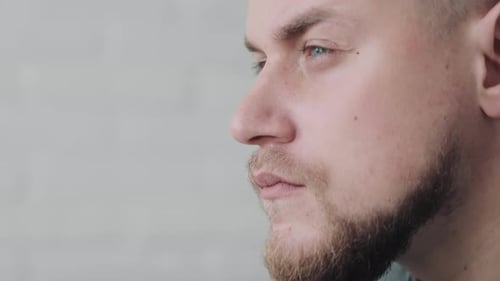 Contemplative Man Closeup Closeup Side View of a Thoughtful Man with a Neutral Background