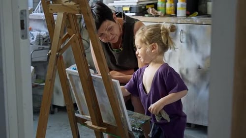 Child Painting with an Grandmother in a Cozy Art Studio