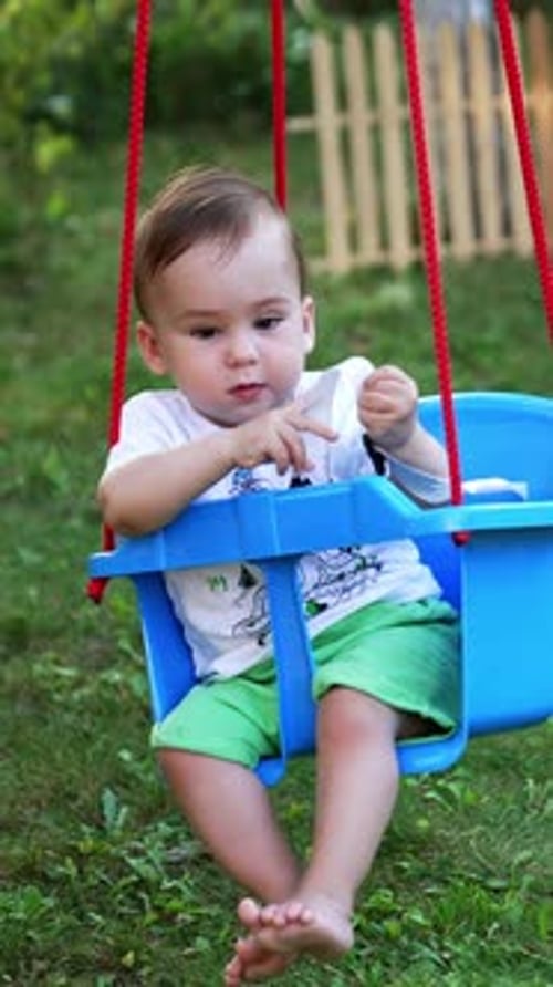 Lovely boy in white t-shirt and green shorts outdoors.