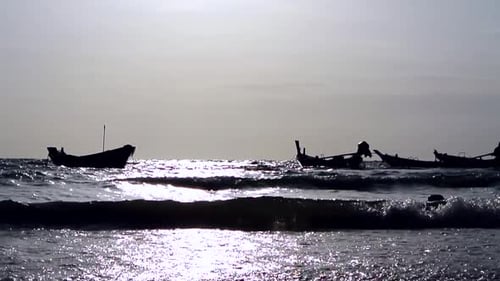 Inselfischerboote, die an der Küste einer tropischen Insel zwischen den Wellen festgemacht haben