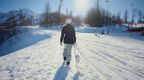Snowboarder Walks Up a Snowy Mountain Slope