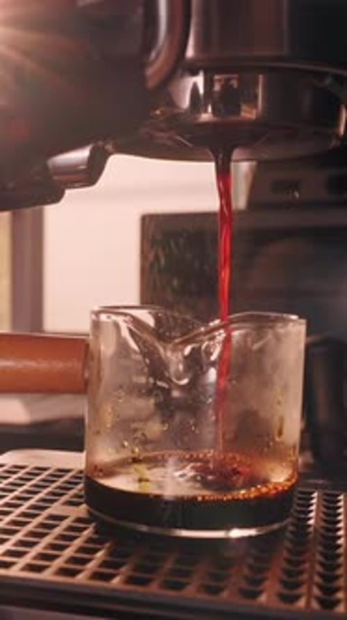 Vertical video. Incorrect Espresso Extraction in Slow Motion with Uneven Coffee Stream from