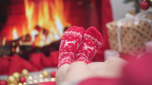 Person Relaxing in Socks by Christmas Fireplace