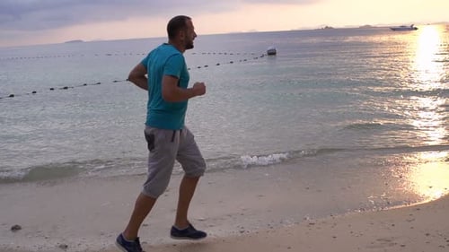 Jeune homme faisant du jogging sur la plage au coucher du soleil, Super 240