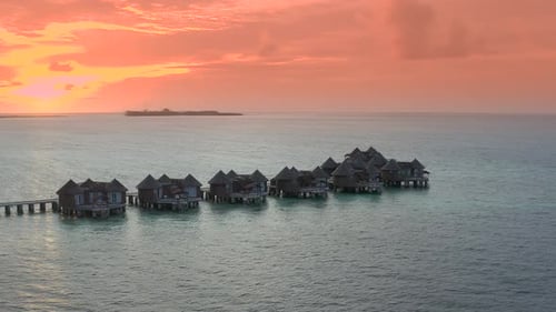 Overwater Villas at the Time Amazing Sunset in Tropical Sea with Coral Reef
