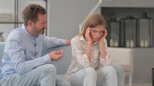 Upset Man and Woman on Couch Arguing