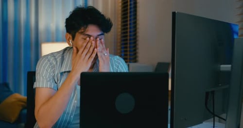 Stressed Young Adult Working at Home on Computers