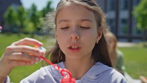 Playful Girl Blowing Soap Bubbles on Meadow Portrait Cheerful Child Playing