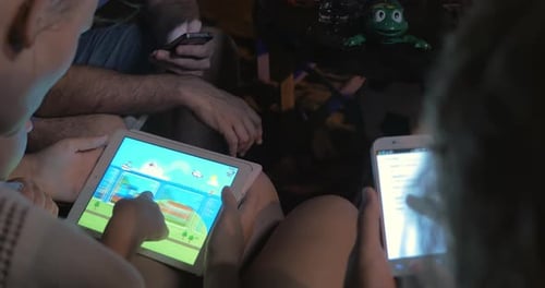 People using tablets and cellphones at night