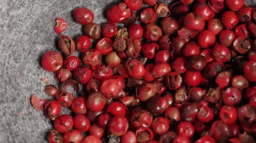 Red Peppercorns Being Poured into a Grey Bowl