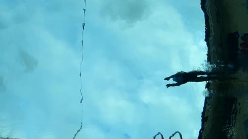 Underwater Slow Motion shot of a swimmer diving into a swimming pool.