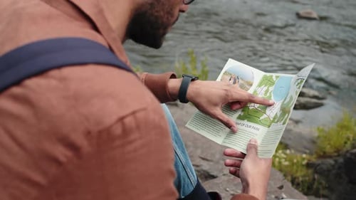 Tourist Sitting and Reading Brochure