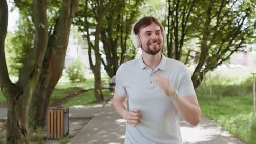 Athletic Fitness Sport Runner Man Training Marathon Run Listening Music in Headphones Workout Cardio