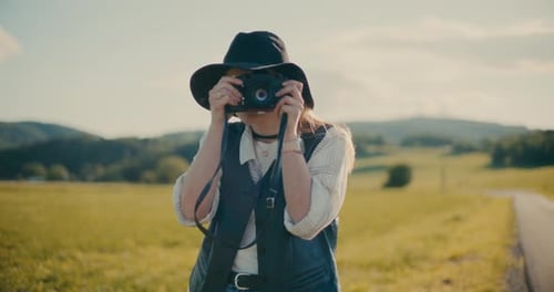 Stylish Woman Taking Picture in Rural Landscape