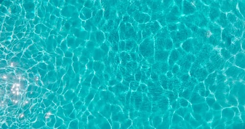 Blue Water in the Swimming Pool with Light Reflections