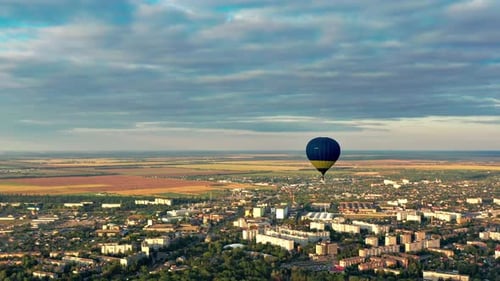 Multicolored balloons fly over trees. Nice top view of the park, forest covered with greenery.