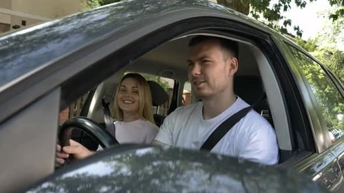 Young couple, boyfriend and girlfriend sitting in car in summer vacation, Poland