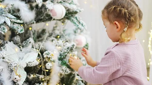 Little Girl Decorating Christmas Tree with Ornament