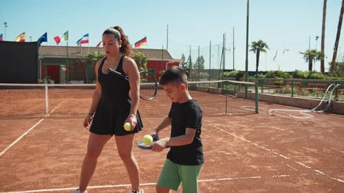 Tennis Coach Helping Boy Improve Balance and Skill