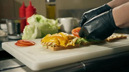 professional kitchen in a restaurant the chef lays out the ingredients for a club sandwich on toast