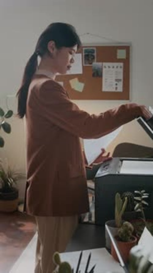 Trabajadora de oficina copiando documentos en una impresora