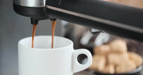 Home Espresso Making Process Coffee Stream Pouring From Machine Into Ceramic Cup