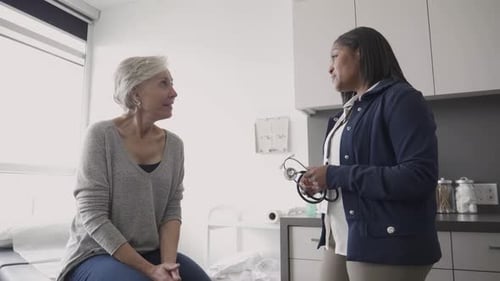 Female Doctor with Stethoscope Talking to Senior Patient in Clinic 10 Seconds or Greater