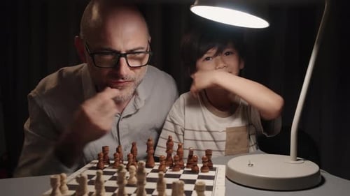Vater und Sohn bewegen abwechselnd Königinnen im Schachspiel