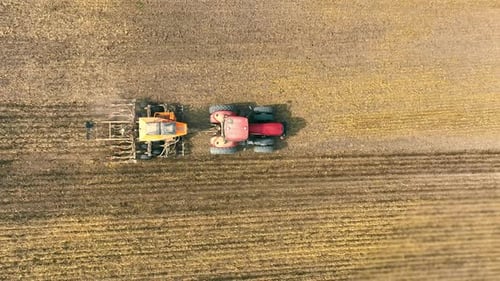 Aerial Top View Tractor with Plough on Agricultural Land Tractor Plowing Field in Farming Landscape