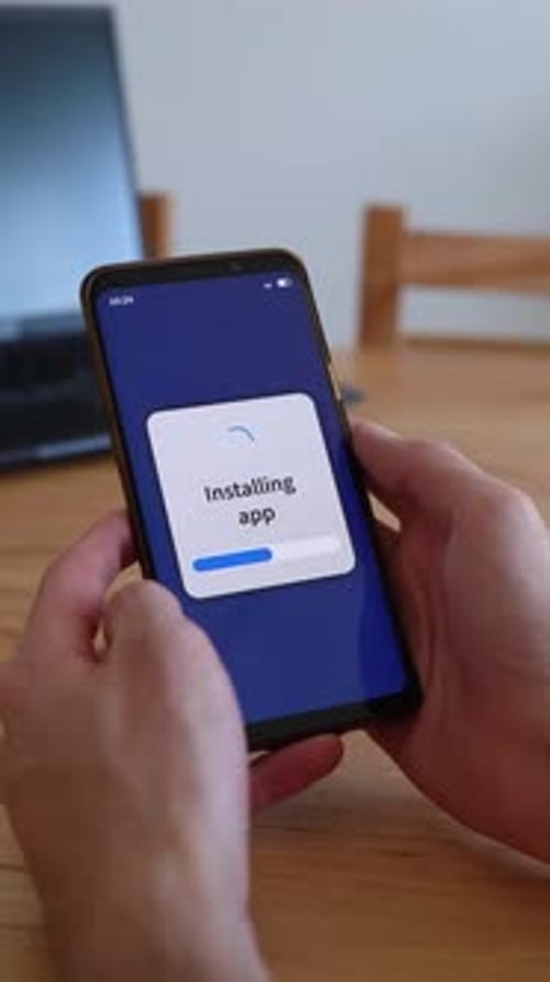 Vertical shot of phone installing new apps.