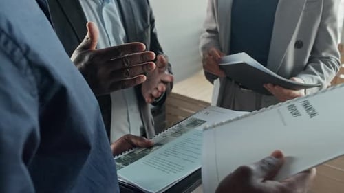 Business Team Discussing Reports Standing in Office