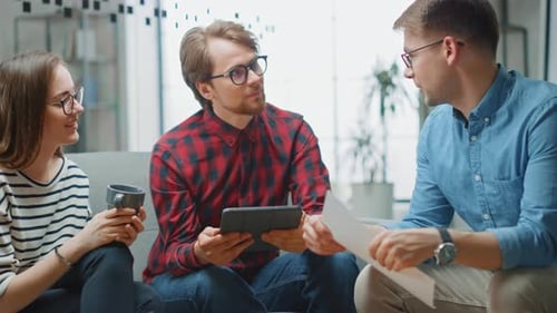Business Professionals Collaborating on a Sofa in an Office