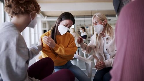 Concerned people comfort upset woman in group setting